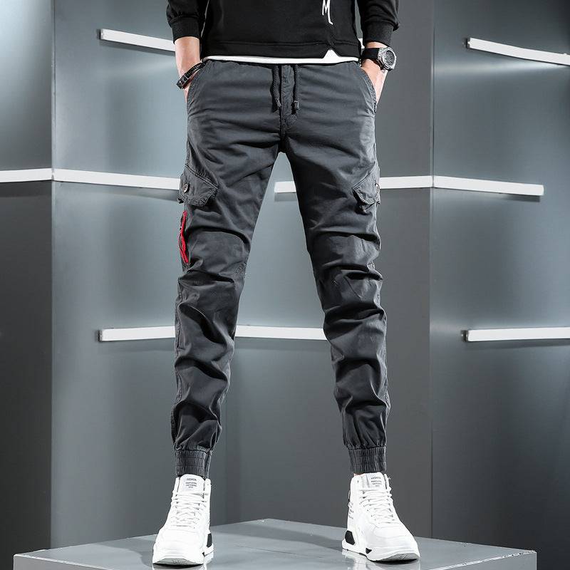 Men's slim overalls in charcoal gray featuring cargo pockets and elastic cuffs, combining comfort and urban style.