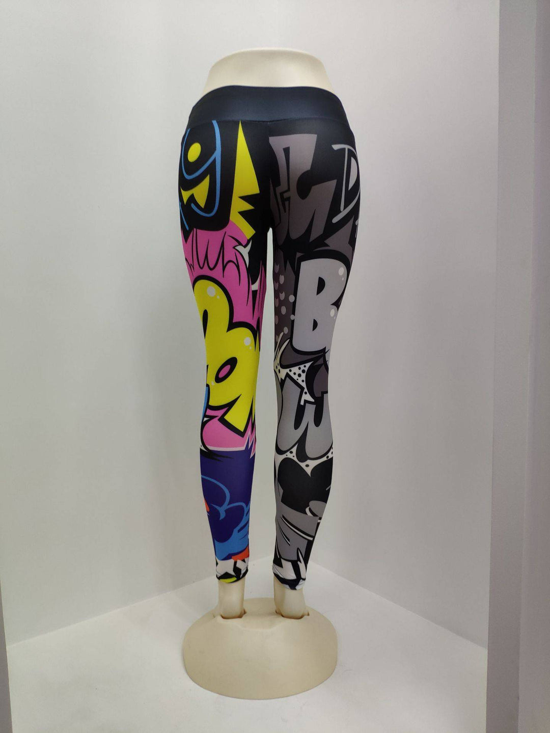 Mannequin wearing multicolor printed yoga leggings for women, showcasing comic-style graphics and slim fit polyester fabric.
