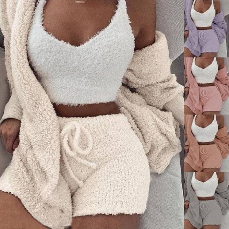 Women wearing cozy cream-colored fleece pajama set with crop top and shorts, plush lounge wear for relaxing at home.