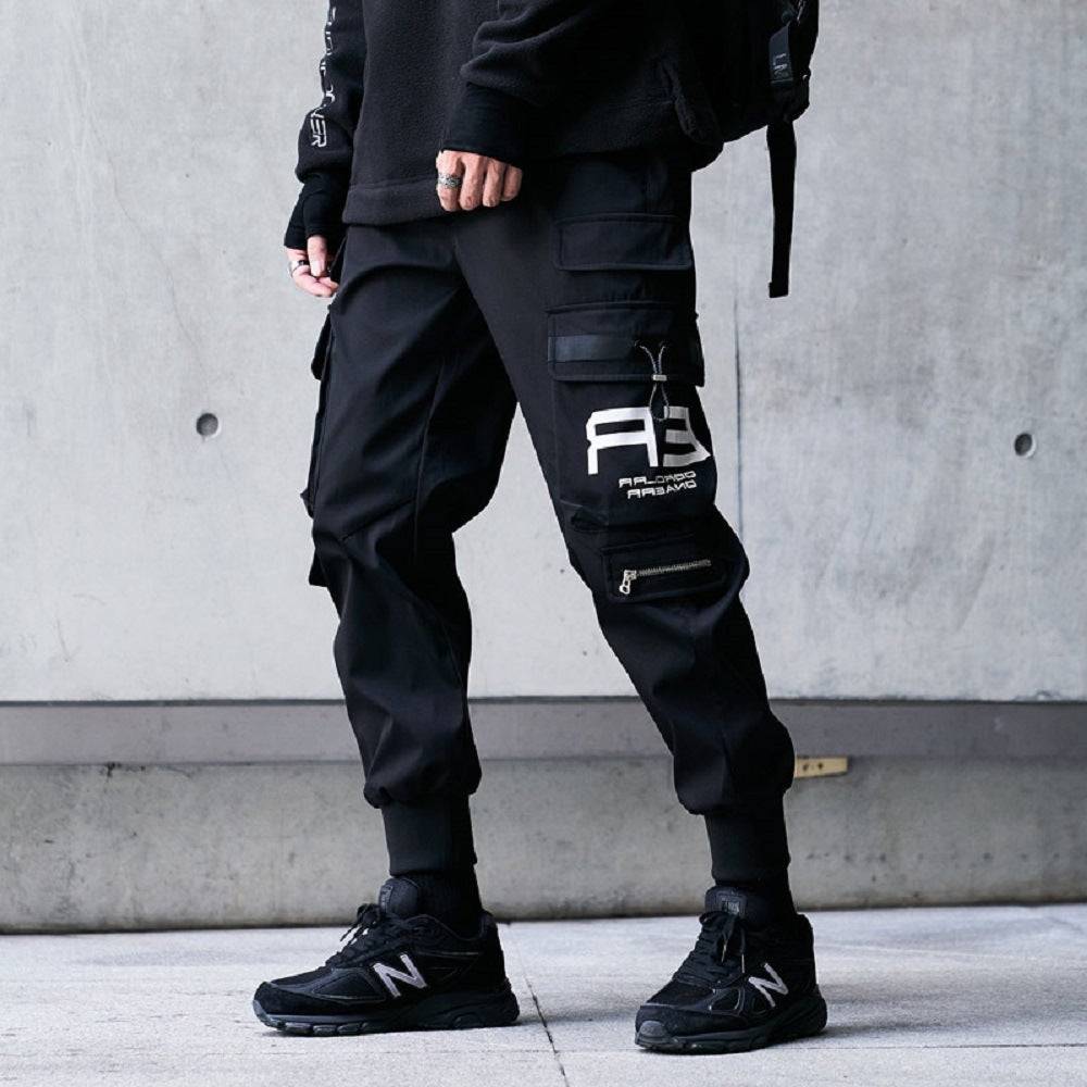 Men's casual workwear pants in black with multiple cargo pockets and graphic print, styled for urban streetwear and comfort.