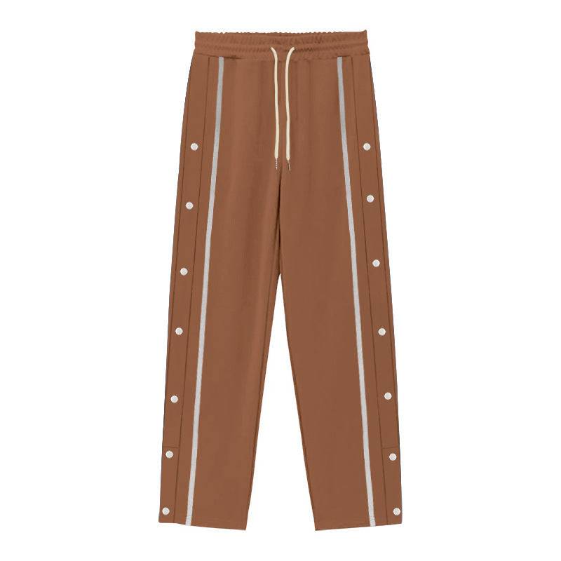 Flat-lay of brown men's casual sports pants with white side stripes and snap buttons, designed for comfort and urban style.