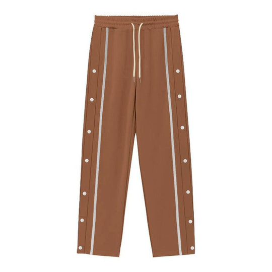 Flat-lay of brown men's casual sports pants with white side stripes and snap buttons, designed for comfort and urban style.