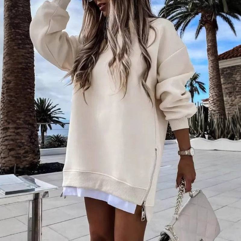 Apricot fall winter pullover sweater for women with side zipper design, styled with white shirt and handbag in a tropical outdoor setting.