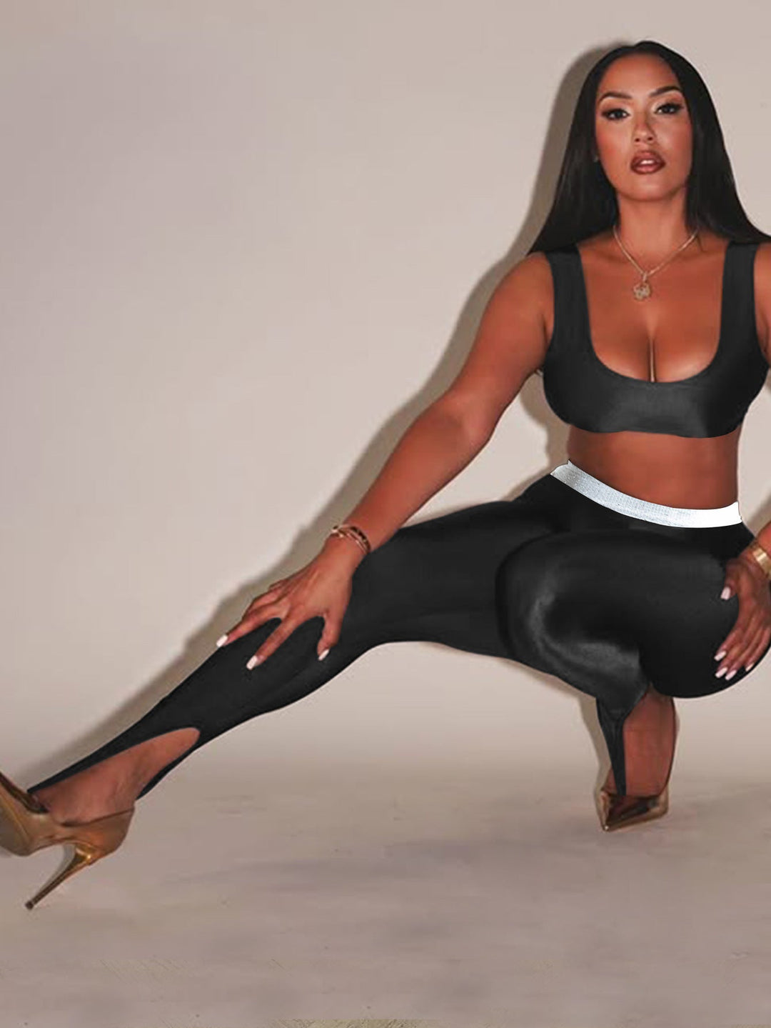 Front Step Shiny Leggings - Slim Fit Nylon Trousers in black, featuring high elasticity and stirrup hem, styled with crop top and heels.