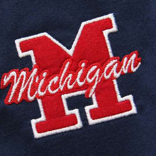 Detailed embroidery of red 'M' and cursive 'Michigan' on navy fabric, showcasing premium stitching on men's hooded short sleeve sweater.