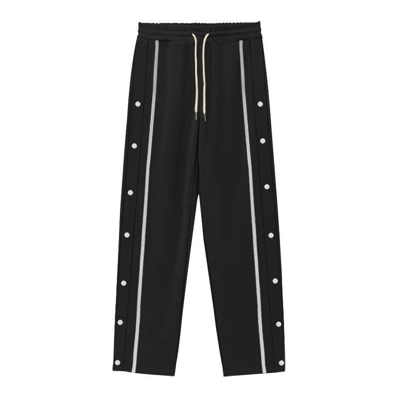 Flat-lay of black men's casual sports pants with gray side stripes and button accents, combining sleek design with comfort.